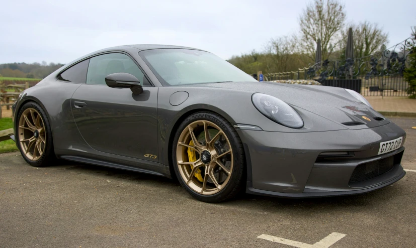 a gray and yellow porsche 9114 in a parking lot