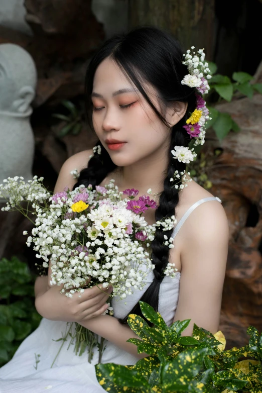 a woman with long black hair holding several small flowers