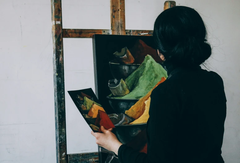 a woman is painting a picture on canvas