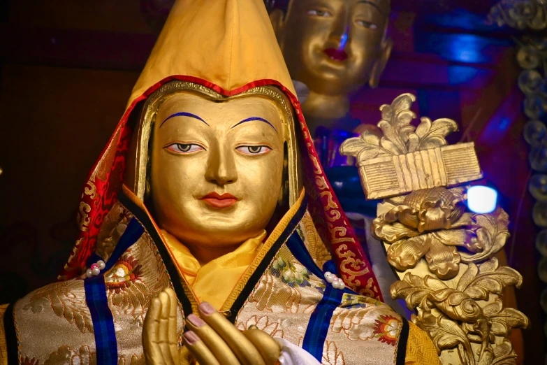 an elaborately painted statue with gold and blue trims