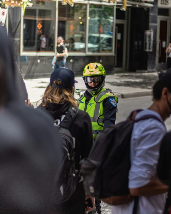 a police officer walks behind a group of people on the street