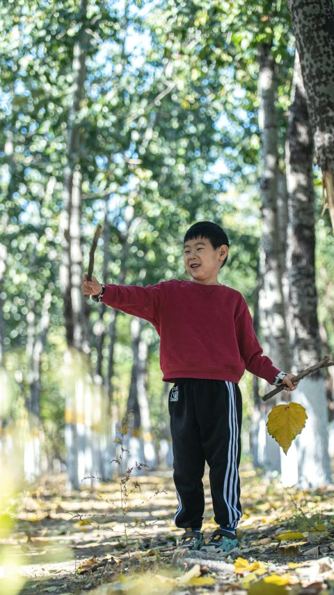 a boy playing in the park with an umbrella