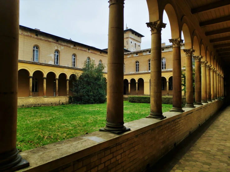 the view from the outside looking at a large building and a grass area