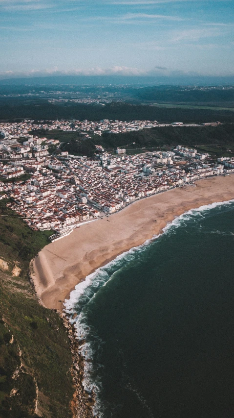 the view over town, ocean, and beach from an airplane