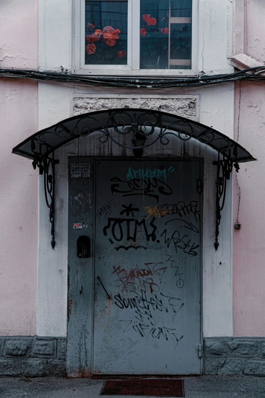 a door and window covered in graffiti, near some building