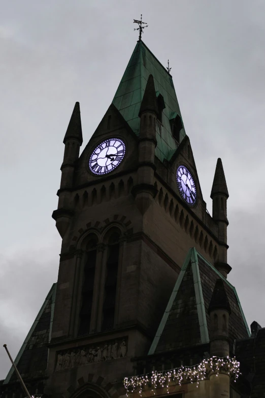 an old church tower with clock faces at night