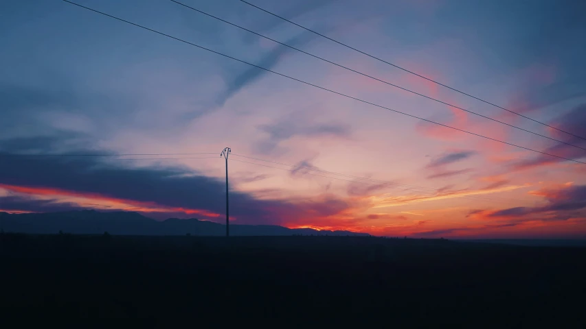 the power lines are tall and can be seen at dusk