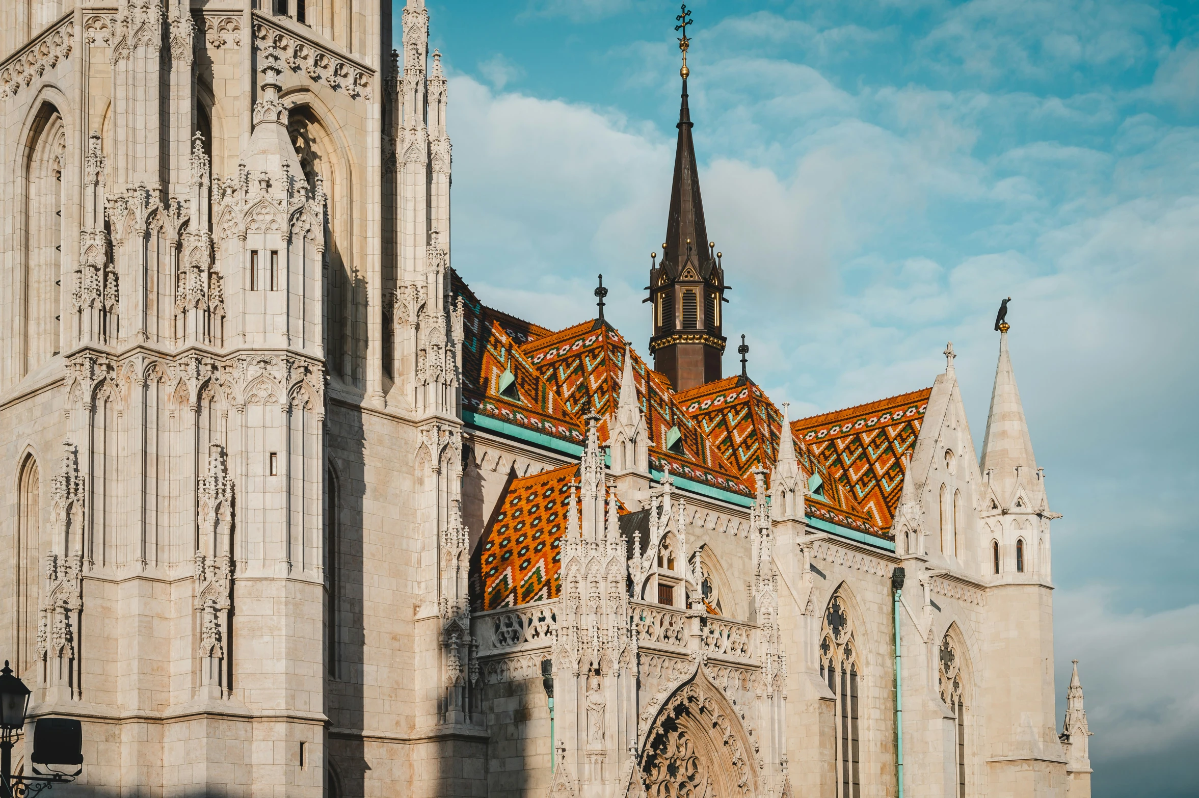 a very old cathedral with some spires and orange tiles