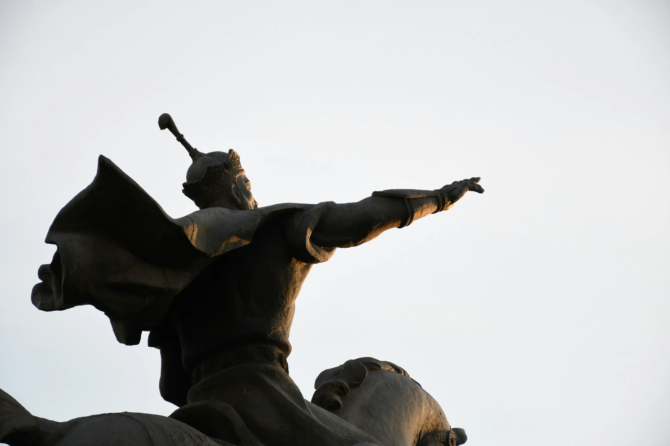 a statue has the arms up, and the legs are folded back