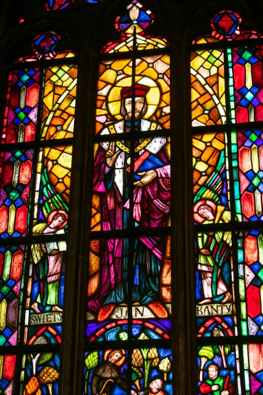 large stained glass window with a saint in the center