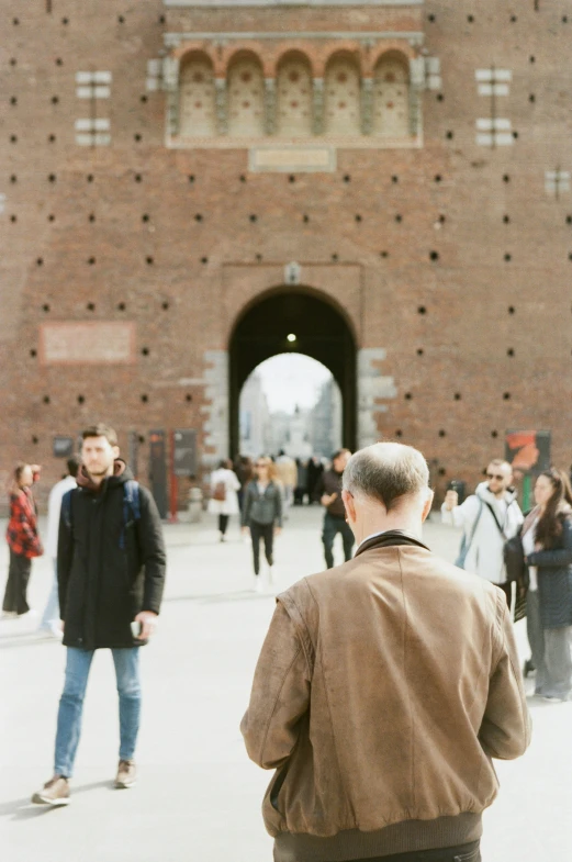 people are walking through the large city under an open tunnel