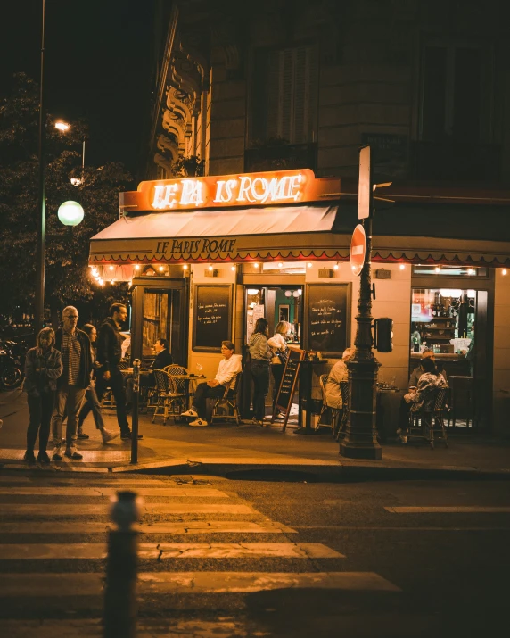 people standing outside of a restaurant at night