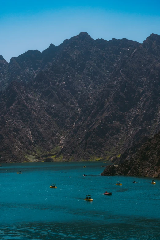 a po of boats in the water with some mountains in the background
