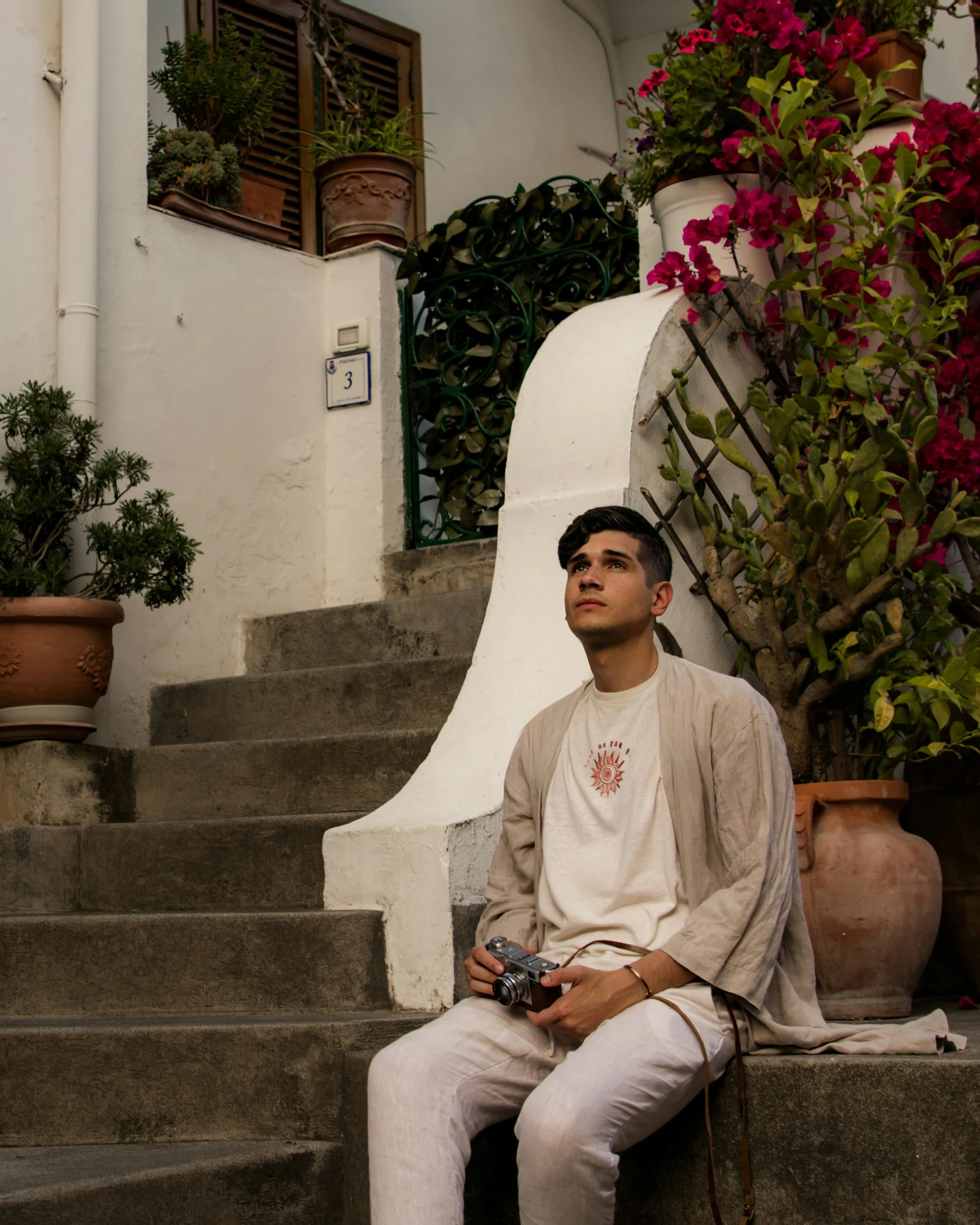 a young man is sitting down near flowers