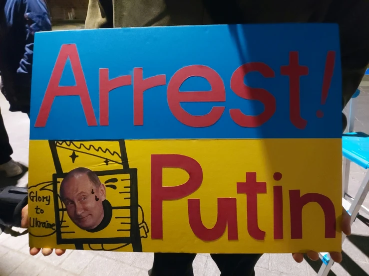 a protester holds up a sign that says,