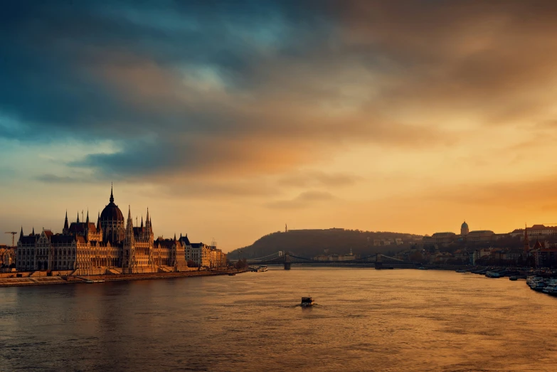 some buildings on the shore of a body of water at dusk