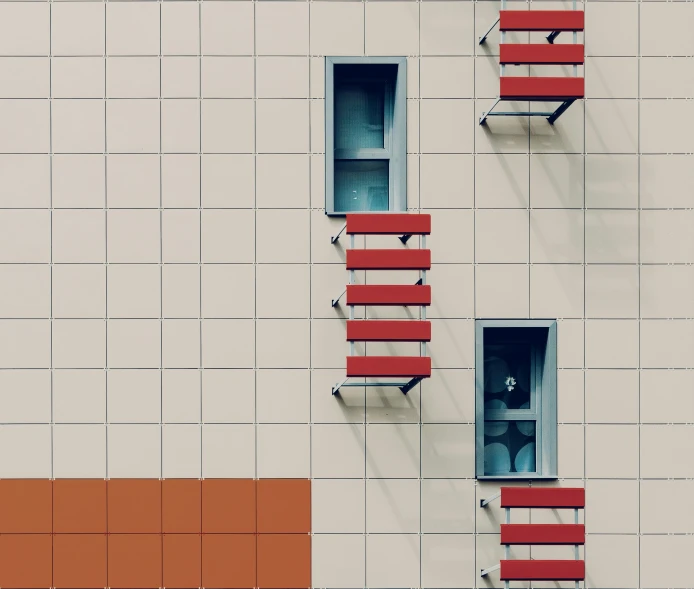 two red seats on an outside wall that look like a building