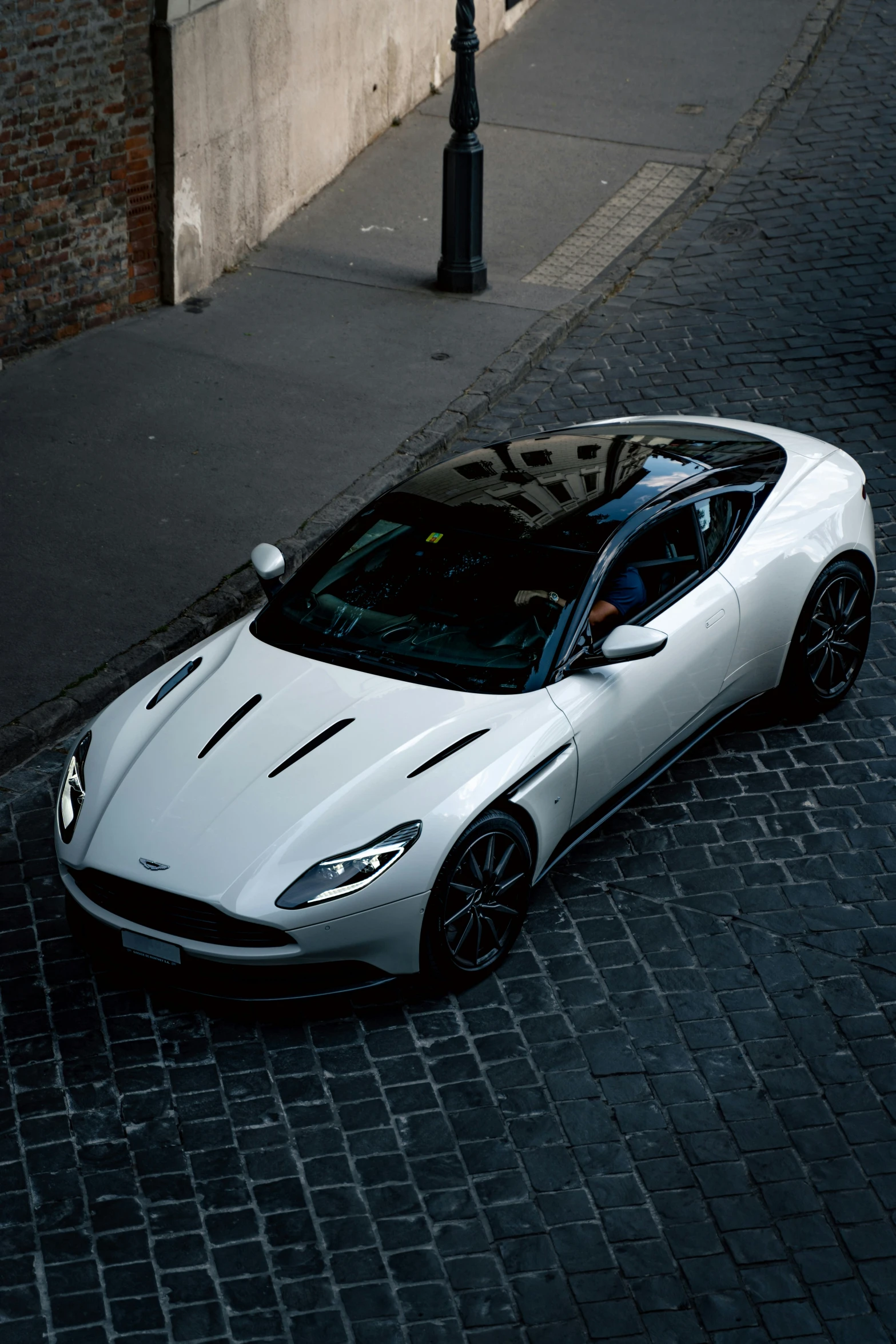 a white luxury car parked next to a street light