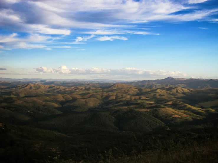 aerial view of mountains, valleys and forests under clouds