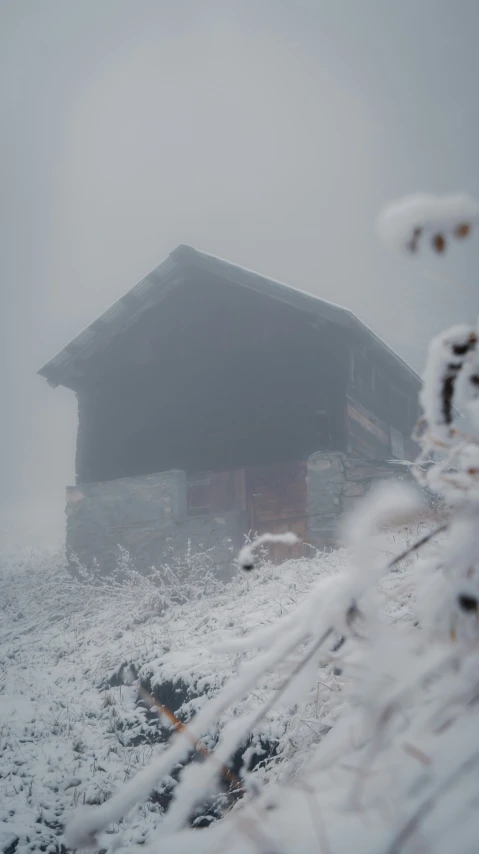 a small building on a hill covered in snow