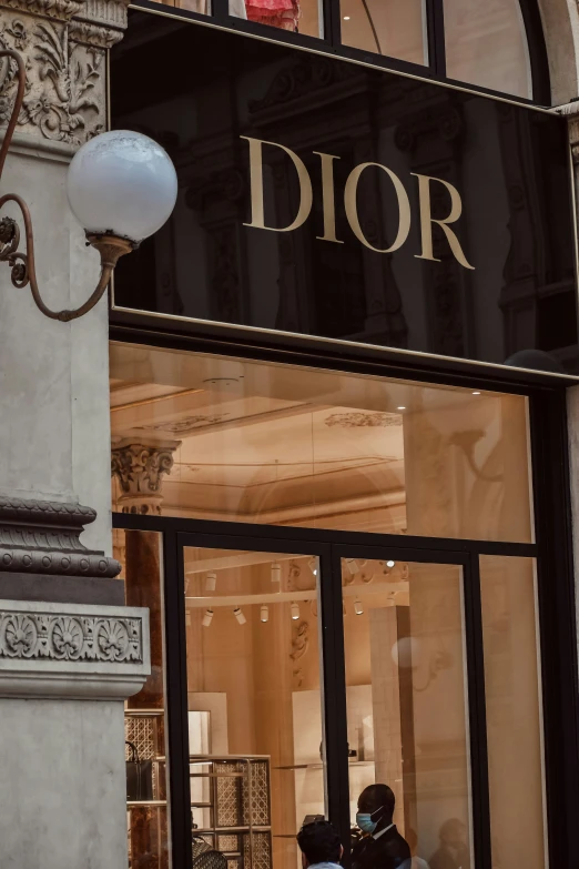 two people in masks, riding motorcycles outside a christian dior store