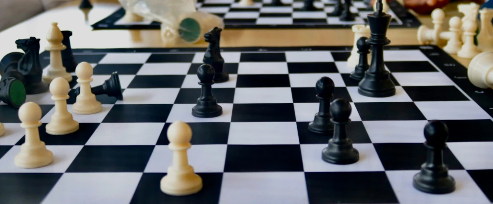 chess set up on the table with the black pawn facing away
