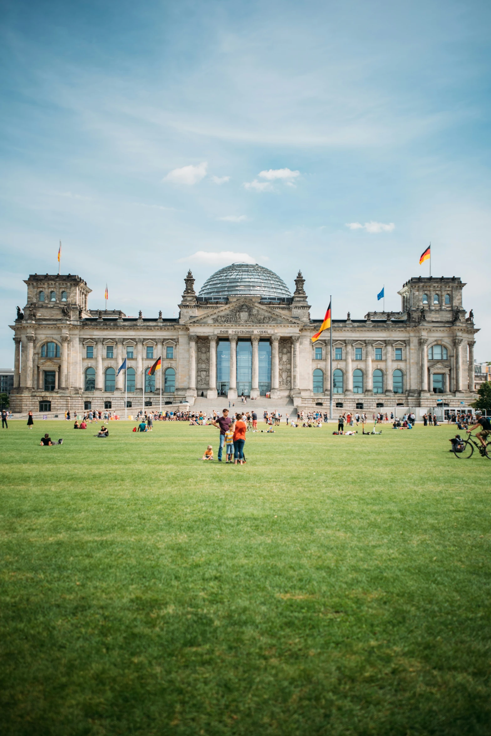 there are many people sitting and walking on the grass