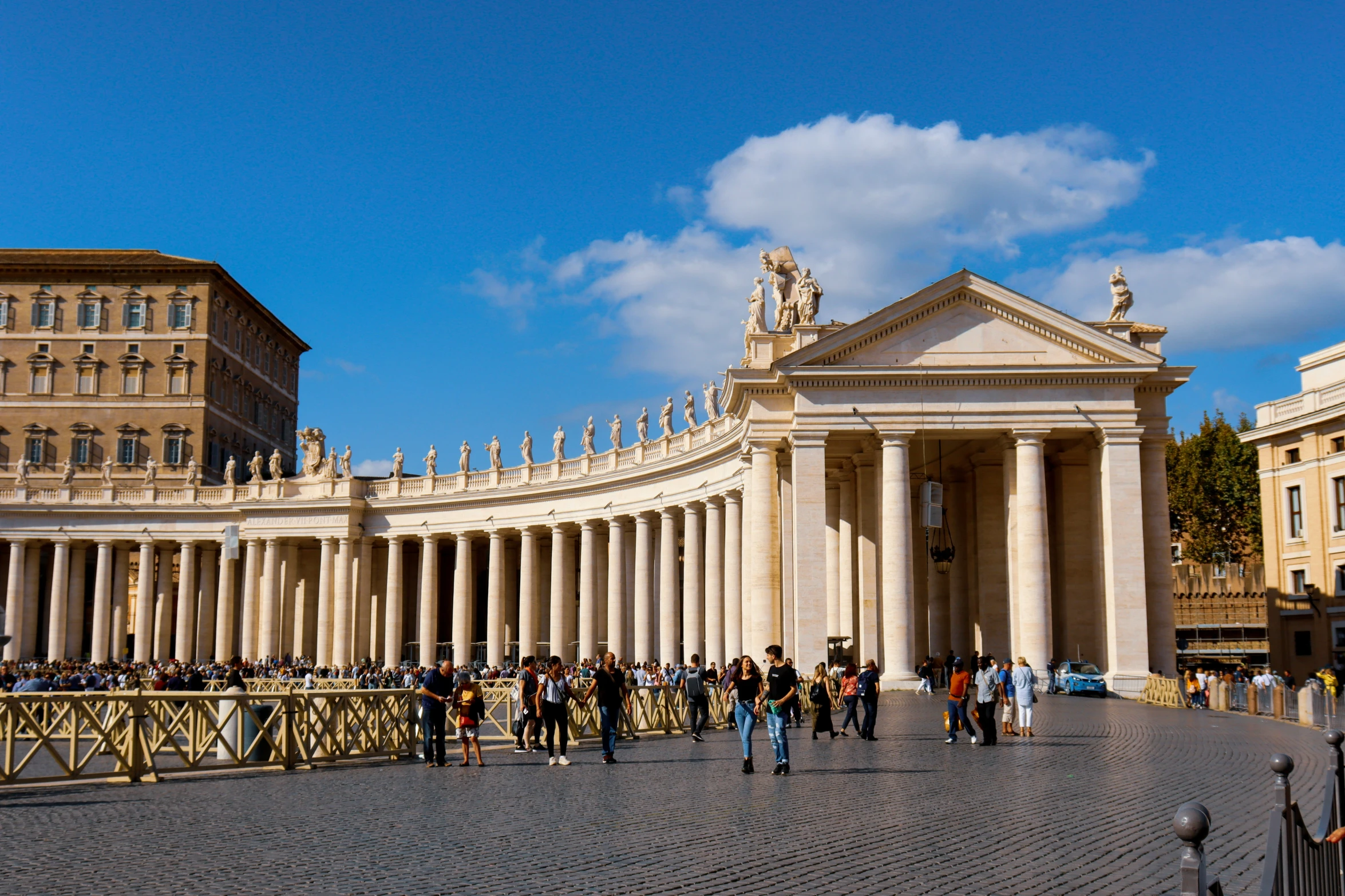 some buildings and people are standing on a sidewalk