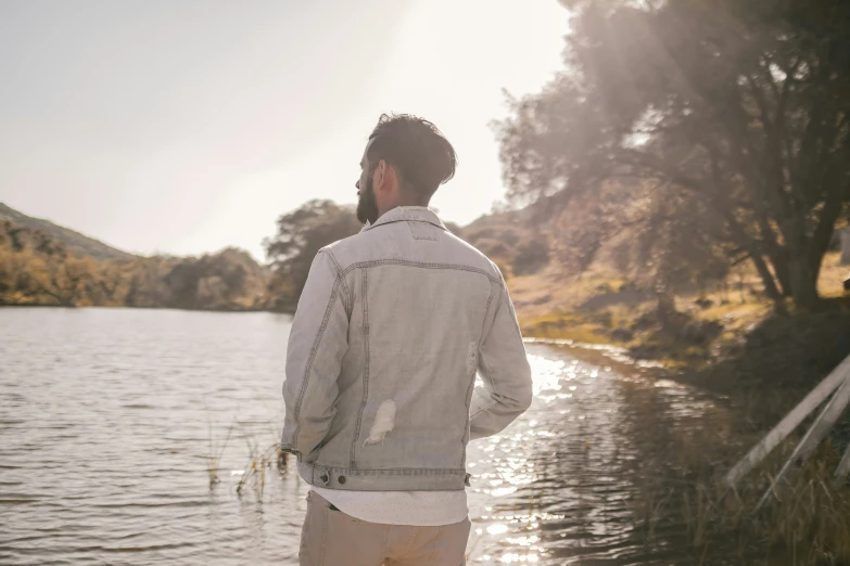 a man is standing in front of a pond and the water