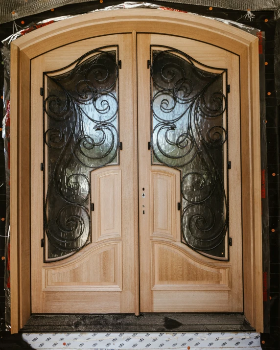 double doors with a glass window and a wreath hanging in front of them