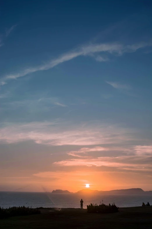 a couple watching the sunset over a beach