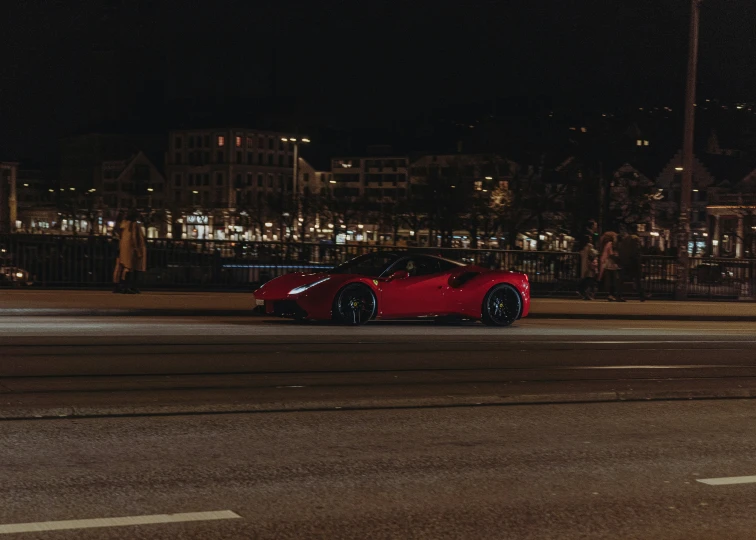 a red car on street near building with city lights