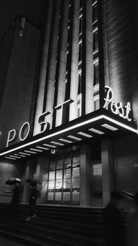 people are walking outside a large building with the word post