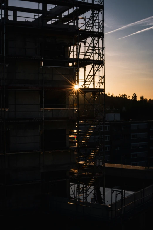 the sun is setting through some scaffolding over the city