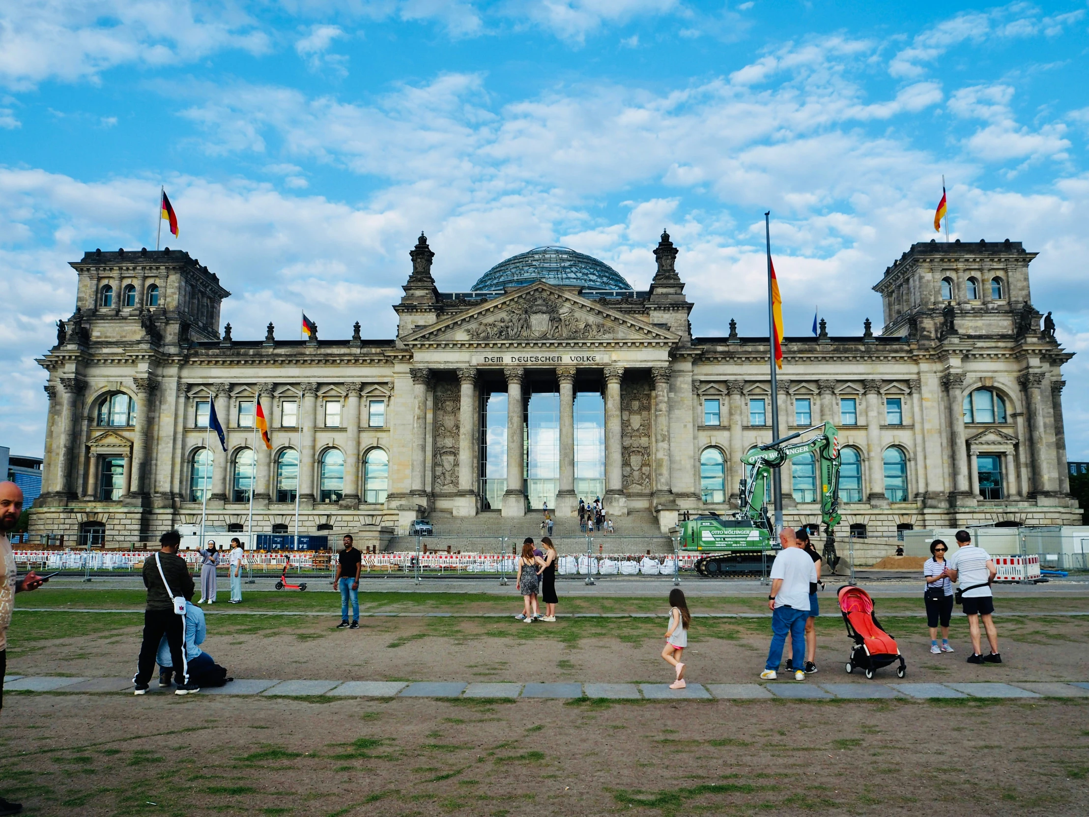 people in front of a large building and trees