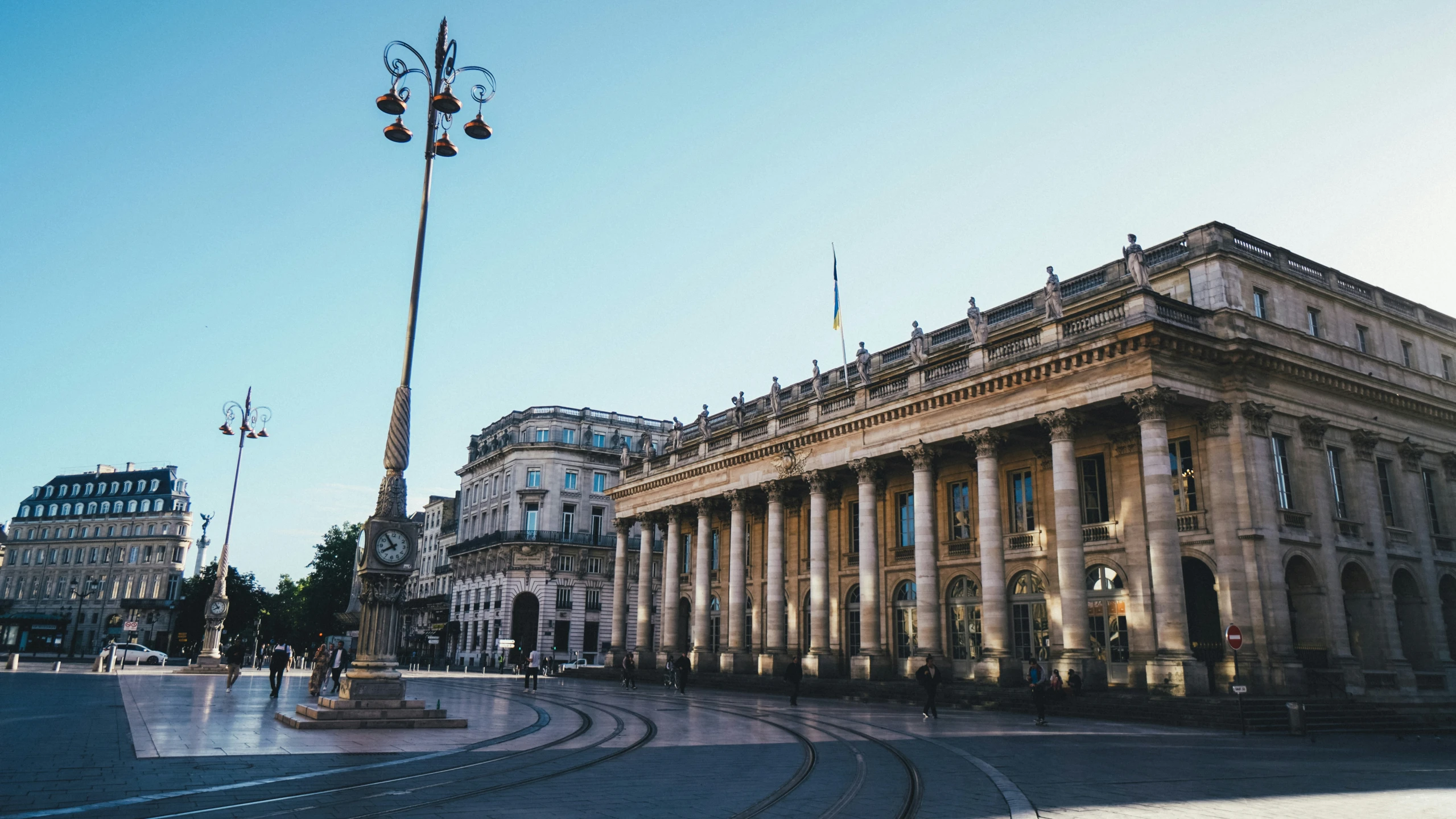 an old building has pillars and is surrounded by smaller buildings