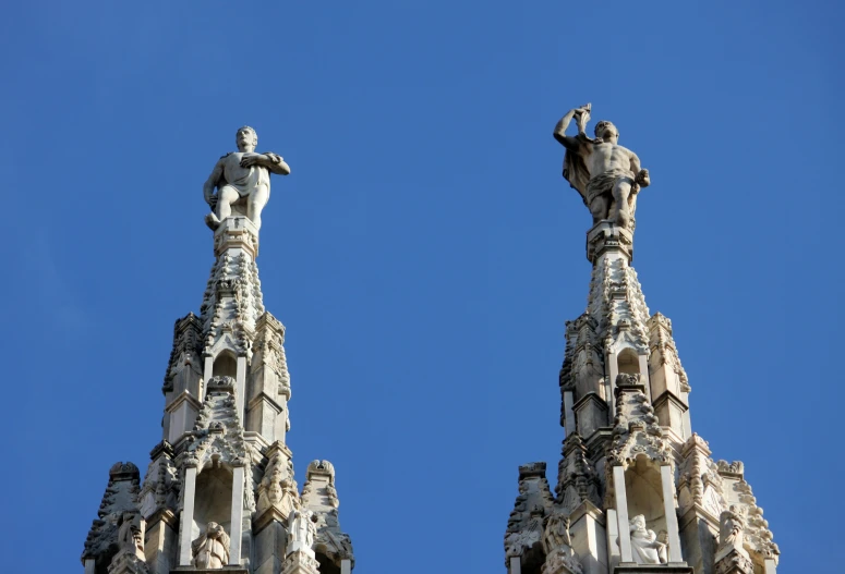 a building with a clock and two statues on top