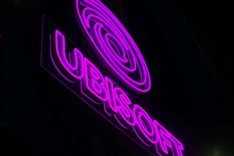 a large neon sign hanging from the side of a building