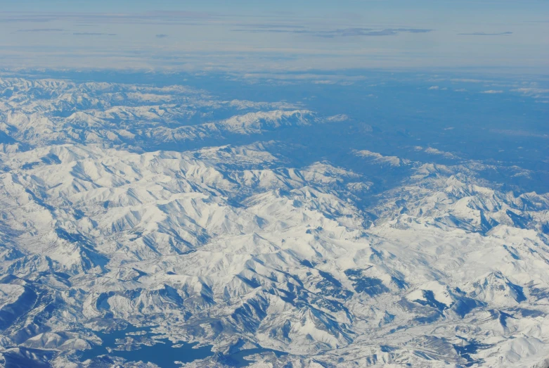 snow covered mountains seen from the window of an airplane