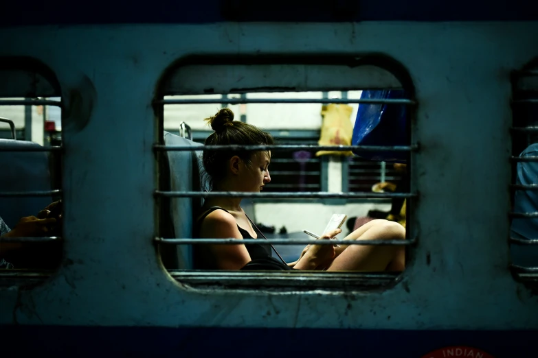 the girl is reading on the train through the window