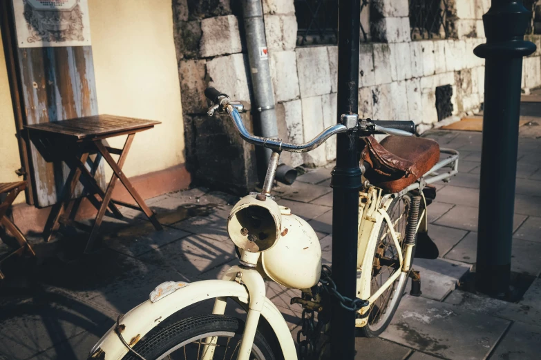 old bike leaning against metal post outside building