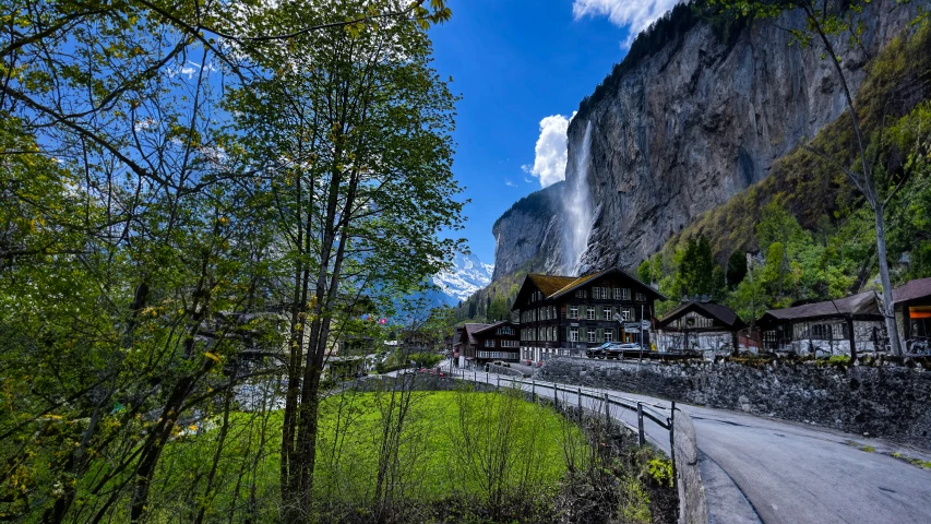 several homes stand near the side of a large rocky cliff