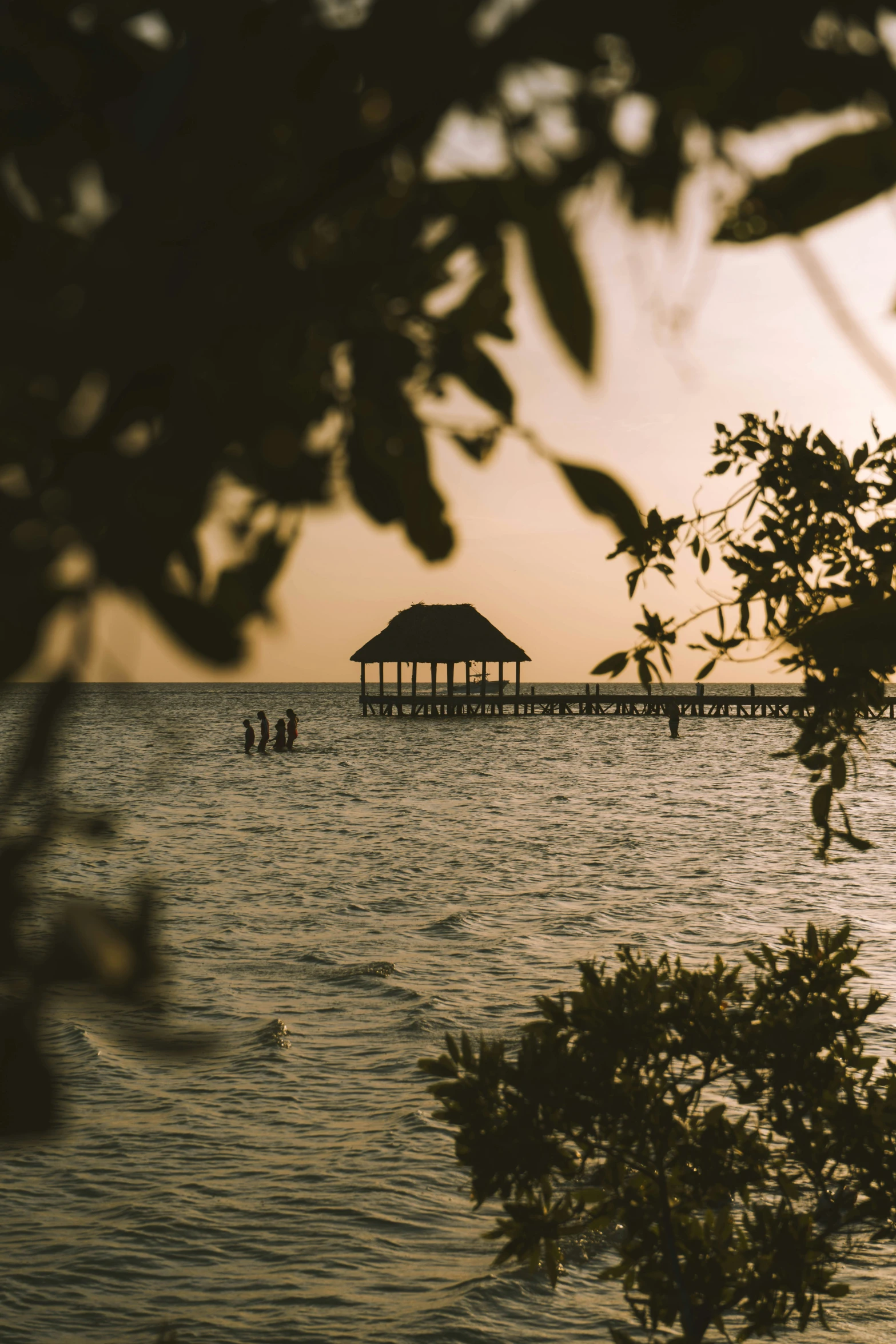 a pier sitting over the ocean with a boat in the water