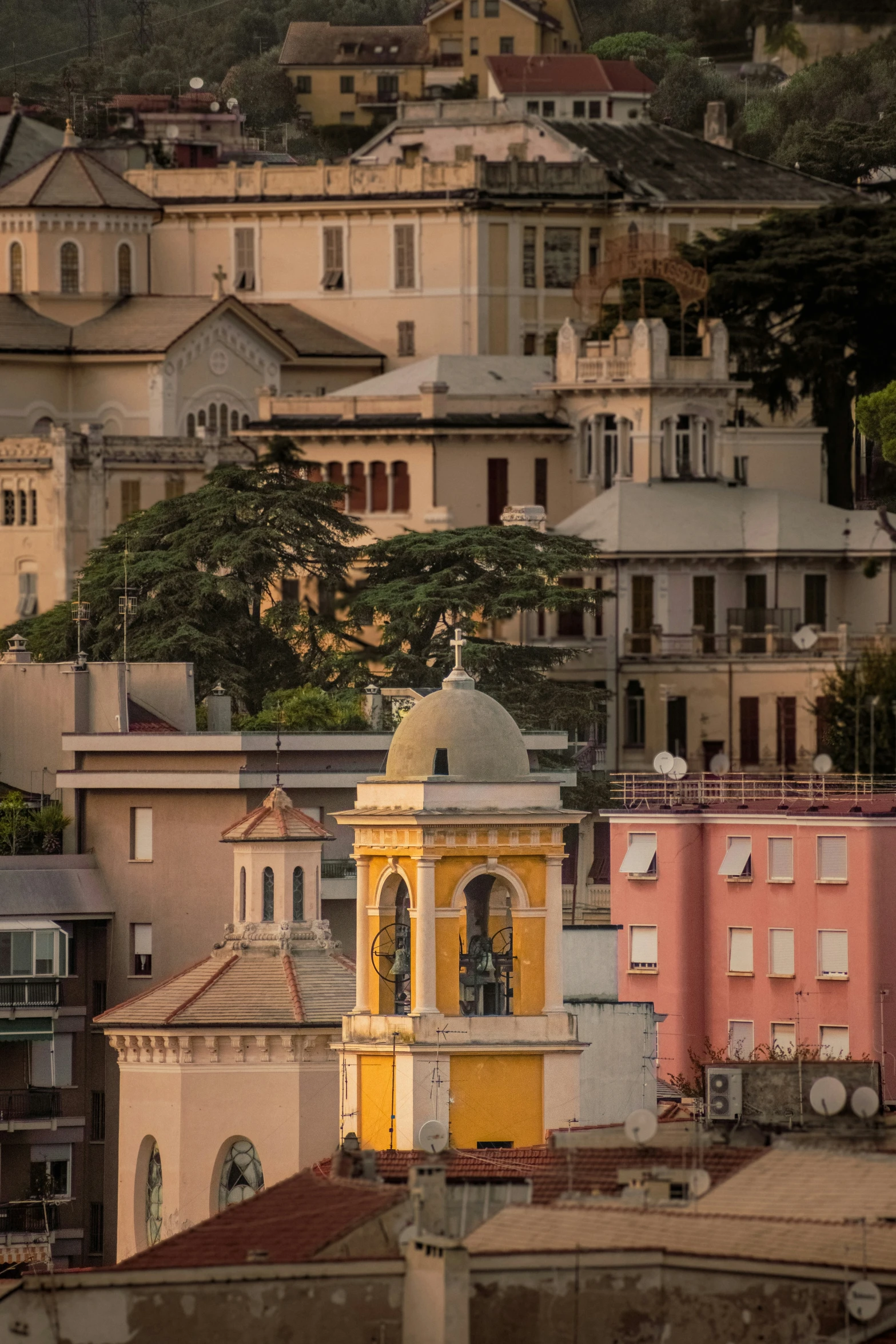 a tall yellow clock tower towering over some buildings