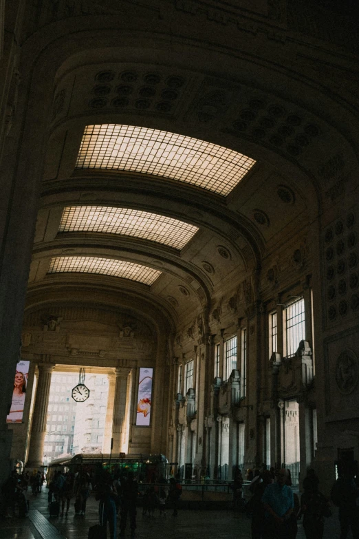 a crowd is standing under the ceiling inside a building