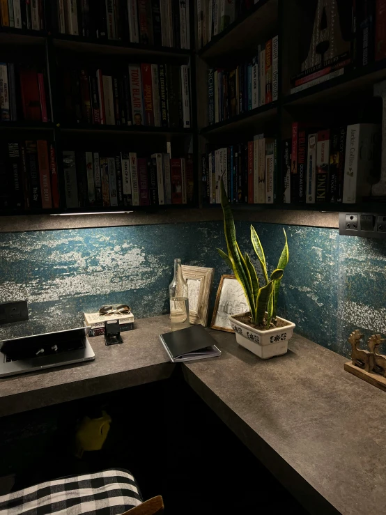 a desk with books and a vase on it