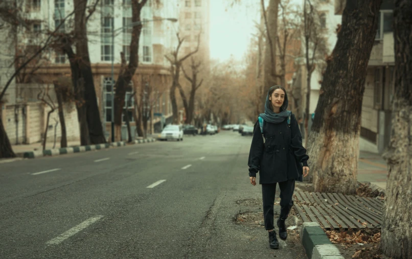 an oriental woman is walking on the side of a road