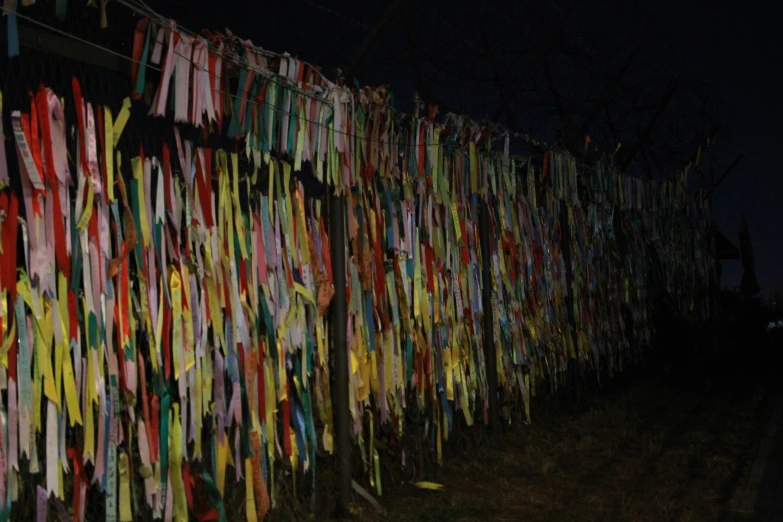 many ski poles are hung to the side of a fence