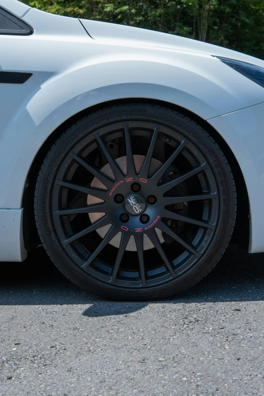 a silver car with black spokes parked in a parking lot