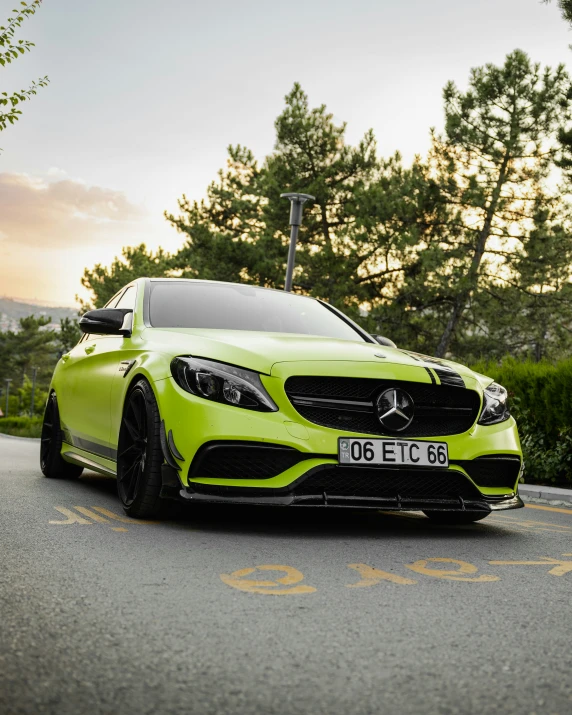 a green mercedes benz amg coupe sitting in the road